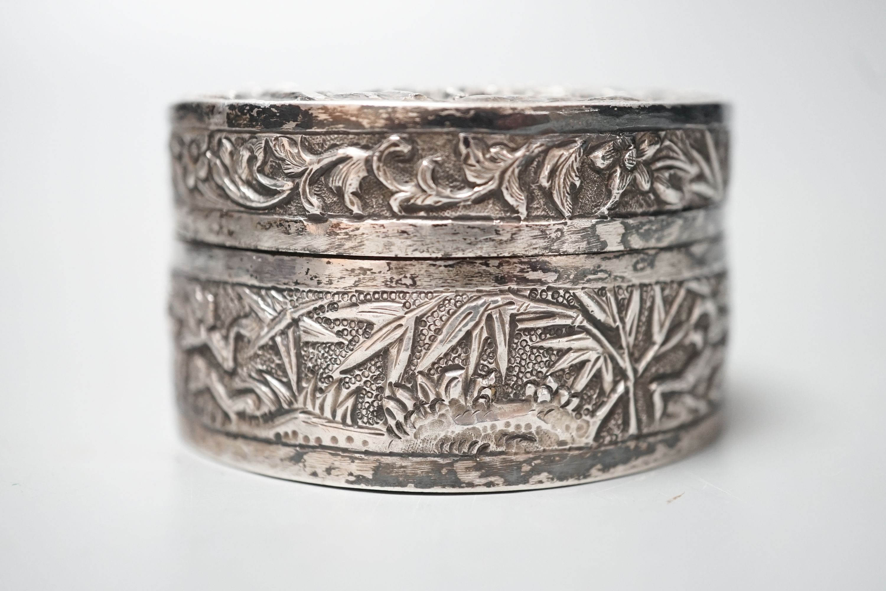 A Chinese embossed white metal circular box and cover, late 19th century, diameter 61mm.